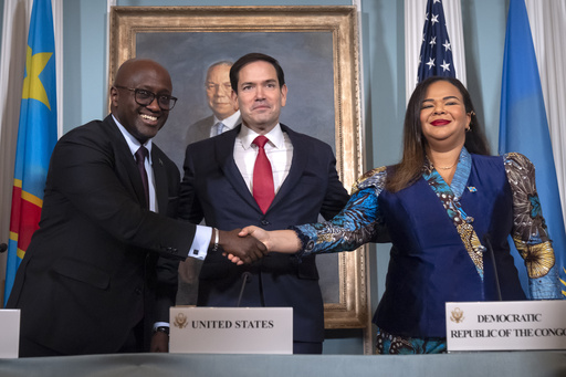 Secretary of State Marco Rubio, center, stands with Rwanda's Foreign Minister Olivier Nduhungirehe, left, and Democratic Republic of the Congo's Foreign Minister Therese Kayikwamba Wagner, right, as they shake hands after signing a peace agreement at the State Department, Friday, June 27, 2025, in Washington. (AP Photo/Mark Schiefelbein).