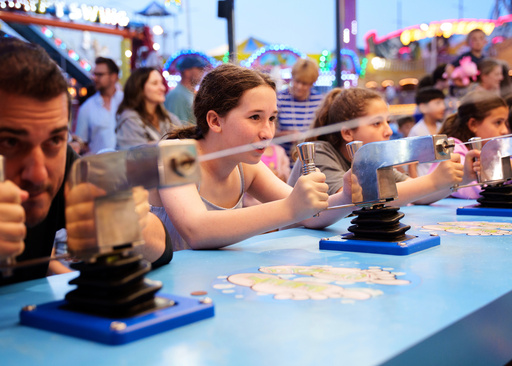 People play a water gun game at Playland's Castaway Cove amusement park, in Ocean City, N.J, on Friday, June 6, 2025. (AP Photo/Mingson Lau)