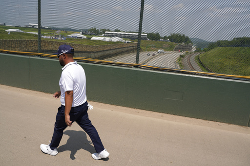 J.J. Spaun walks across a bridge over the Pennsylvania Turnpike, which runs through Oakmont Country Club, during the first round of the U.S. Open golf tournament Thursday, June 12, 2025, in Oakmont, Pa. (AP Photo/Charlie Riedel)