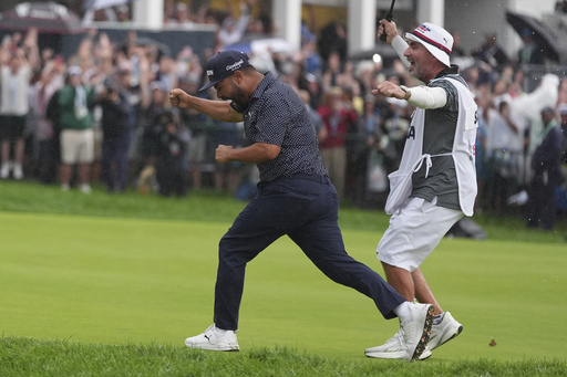 J.J. Spaun celebrates with his caddie, Mark Carens, after making a birdie putt on the 18th hole during the final round of the U.S. Open golf tournament at Oakmont Country Club Sunday, June 15, 2025, in Oakmont, Pa. (AP Photo/Seth Wenig)
