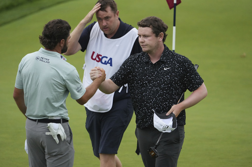 Robert MacIntyre, of Scotland, and Cameron Young, left, shake hands after finishing the final round of the U.S. Open golf tournament at Oakmont Country Club Sunday, June 15, 2025, in Oakmont, Pa. (AP Photo/Gene J. Puskar)