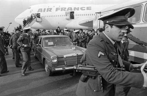 FILE - Ayatollah Ruhollah Khomeini has a heavy escort as he enters car to leave the airport in Tehran, Iran, Feb. 1, 1979, after arriving back in the country on a chartered Air France Boing 747. (AP Photo/FY, File)