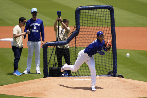 Los Angeles Dodgers' pitcher Shohei Ohtani, center, throws live batting practice as pitching coach Mark Prior, second from left, watches prior to a baseball game against the New York Yankees, Saturday, May 31, 2025, in Los Angeles. (AP Photo/Mark J. Terrill)
