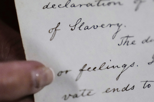 Historian Jennifer Cromack points out the word "Slavery" on a recently found, 178-year-old anti-slavery scroll at Grotonwood, the home mission of The American Baptist Churches of Massachusetts, Thursday, June 26, 2025, in Groton, Mass. (AP Photo/Charles Krupa)