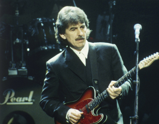 FILE - George Harrison performs at a concert in London on April 6, 1992. (AP Photo/Max Nash, File)