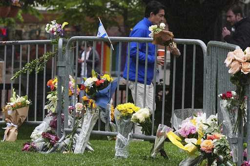 FILE - Bouquets of flowers stand along a makeshift memorial for victims of an attack outside of the Boulder County, Colo., courthouse on Tuesday, June 3, 2025, in Boulder, Colo. (AP Photo/David Zalubowski,File)