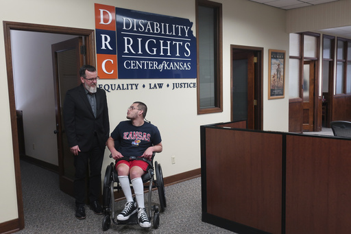 Rocky Nichols, left, executive director of the Disability Rights Center of Kansas, and Matthew Hull, right, a Kansas resident who has cerebral palsy, speak at the center in Topeka, Kans., June 18, 2025. (AP Photo/John Hanna)