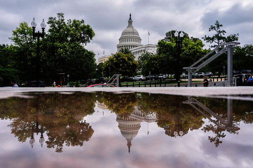The U.S. Capitol is reflected in a puddle outside of the Rayburn House Office Building, Wednesday, July 16, 2025, on Capitol Hill in Washington. (AP Photo/Julia Demaree Nikhinson)