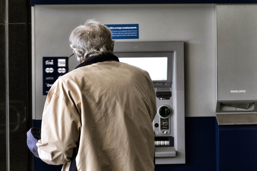 FILE - A customer makes a transaction at an automatic teller machine in Los Angeles on March 27, 2023. (AP Photo/Richard Vogel, File)
