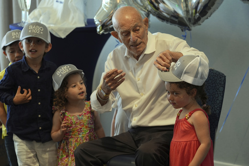 Harold Terens gifts customized hats to his great grandchildren during his 102 birthday party Saturday, July 26, 2025, in Delray Beach, Fla. (AP Photo/Marta Lavandier)
