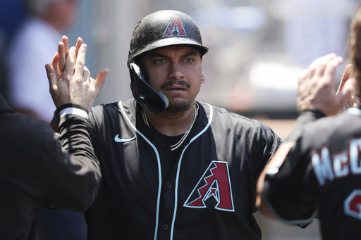 Arizona Diamondbacks' Josh Naylor celebrates in the dugout with his teammates after scoring during the fourth inning of a baseball game against the Los Angeles Angels in Anaheim, Calif., Sunday, July 13, 2025. (AP Photo/Jessie Alcheh)