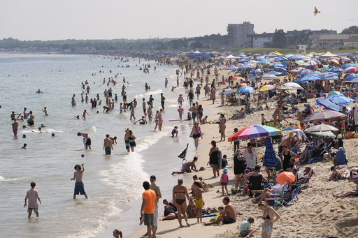 A crowd seeks relief from the heat Tuesday, July 29, 2025, at Old Orchard Beach, Maine. (AP Photo/Robert F. Bukaty)