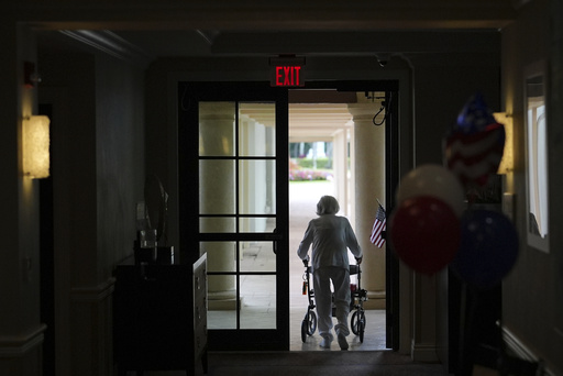 A woman uses a walker as she exits an assisted living building at the Toby and Leon Cooperman Sinai Residences, July 4, 2025, in Boca Raton, Fla. (AP Photo/Rebecca Blackwell)