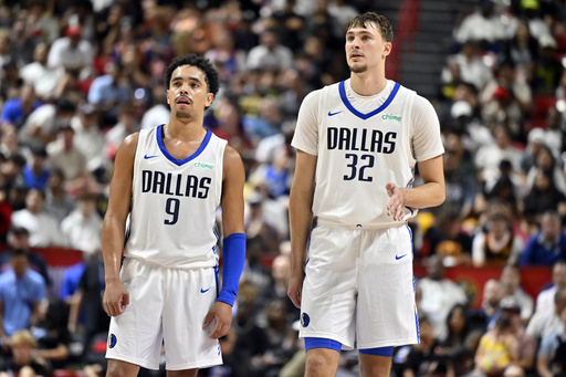 Dallas Mavericks guard Ryan Nembhard (9) and forward Cooper Flagg (32) look on during the second half of an NBA summer league basketball game against the Los Angeles Lakers, Thursday, July 10, 2025, in Las Vegas. (AP Photo/David Becker)