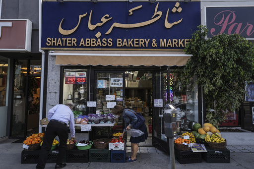 Two shoppers select items at a grocery store in the "Tehrangeles" neighborhood of Los Angeles Tuesday, June 24, 2025. (AP Photo/Jae C. Hong)