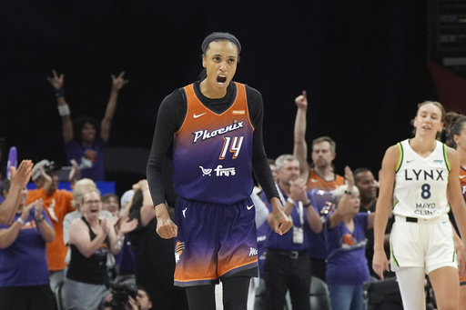 Phoenix Mercury forward DeWanna Bonner celebrates a Mercury score as Minnesota Lynx forward Alanna Smith (8) pauses on the court during the second half of a WNBA basketball game Wednesday, July 9, 2025, in Phoenix. (AP Photo/Ross D. Franklin)