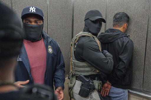 FILE - Immigration and Customs Enforcement agents escort a detained immigrant into an elevator after he exited an immigration courtroom, Tuesday, June 17, 2025, in New York. (AP Photo/Olga Fedorova, file)