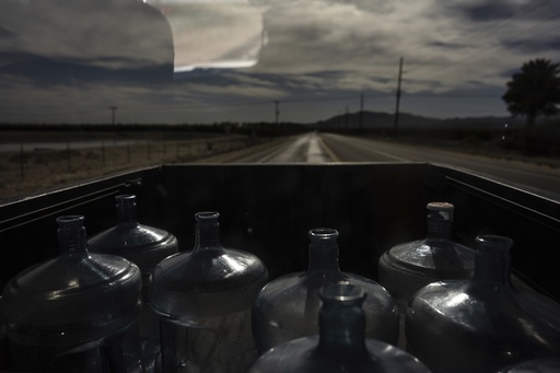Empty water jugs sit in the bed of a pickup truck as Agustin Toledo and his wife, Ricarda, mobile home residents in Southern California's eastern Coachella Valley, travel to a nearby water store to refill them in Oasis, Calif., Wednesday, Oct. 30, 2024. (AP Photo/Jae C. Hong)