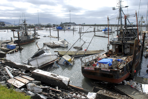 FILE - Sunken and damaged boats rest in the boat basin after a powerful tsunami sent repeated surges that broke up docks and tore loose boats in Crescent City, Calif., March 12, 2011. (AP Photo/Jeff Barnard, File)