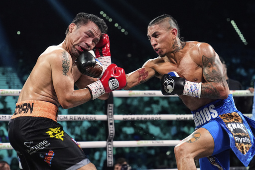 Manny Pacquiao, left, fights Mario Barrios in a welterweight title boxing match Saturday, July 19, 2025, in Las Vegas. (AP Photo/John Locher)