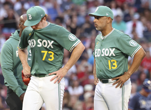 Boston Red Sox pitcher Hunter Dobbins (73) walks off the mound next to manager Alex Cora (13) after an injury during the second inning of a baseball game against the Tampa Bay Rays, Friday, July 11, 2025, in Boston. (AP Photo/Mark Stockwell)