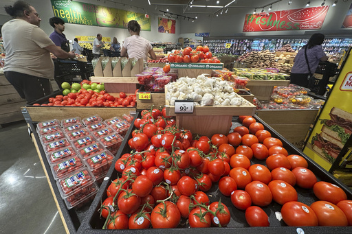 Tomatoes are displayed as customers shop at a grocery store in Glenview, Ill., Tuesday, July 15, 2025. (AP Photo/Nam Y. Huh)
