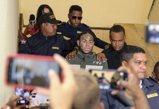 FILE - Rapper Daniel Hernandez, known as Tekashi 6ix9ine, is escorted by police as he arrives for a court hearing at the Palace of Justice, in Santo Domingo, Dominican Republic, on Jan. 25, 2024. (AP Photo/Ricardo Hernandez, File)