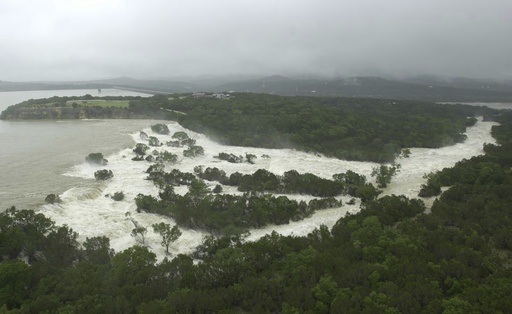 FILE - Water overflows from the Canyon Lake spillway near New Braunfels, Texas, Friday, July 5, 2002, adding to the flood waters along the Guadalupe River. (AP Photo/Eric Gay, File)