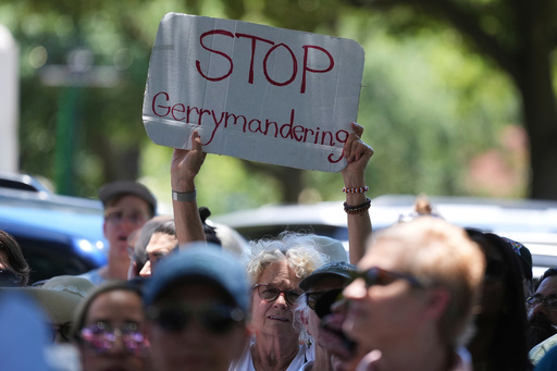 A woman holds a sign during a rally to protest against redistricting hearings at the Texas Capitol, Thursday, July 24, 2025, in Austin, Texas. (AP Photo/Eric Gay)