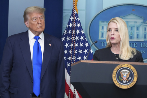 Attorney General Pam Bondi speaks to reporters as President Donald Trump listens, Friday, June 27, 2025, in the briefing room of the White House in Washington. (AP Photo/Jacquelyn Martin)