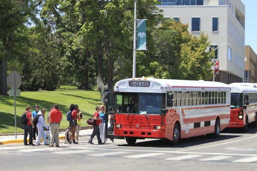 Students carry their belongings as they board buses during what University of New Mexico officials called a "staged, tactical evacuation" following an early morning shooting on the campus in Albuquerque, New Mexico, on Friday, July 25, 2025. (AP Photo/Susan Montoya Bryan)
