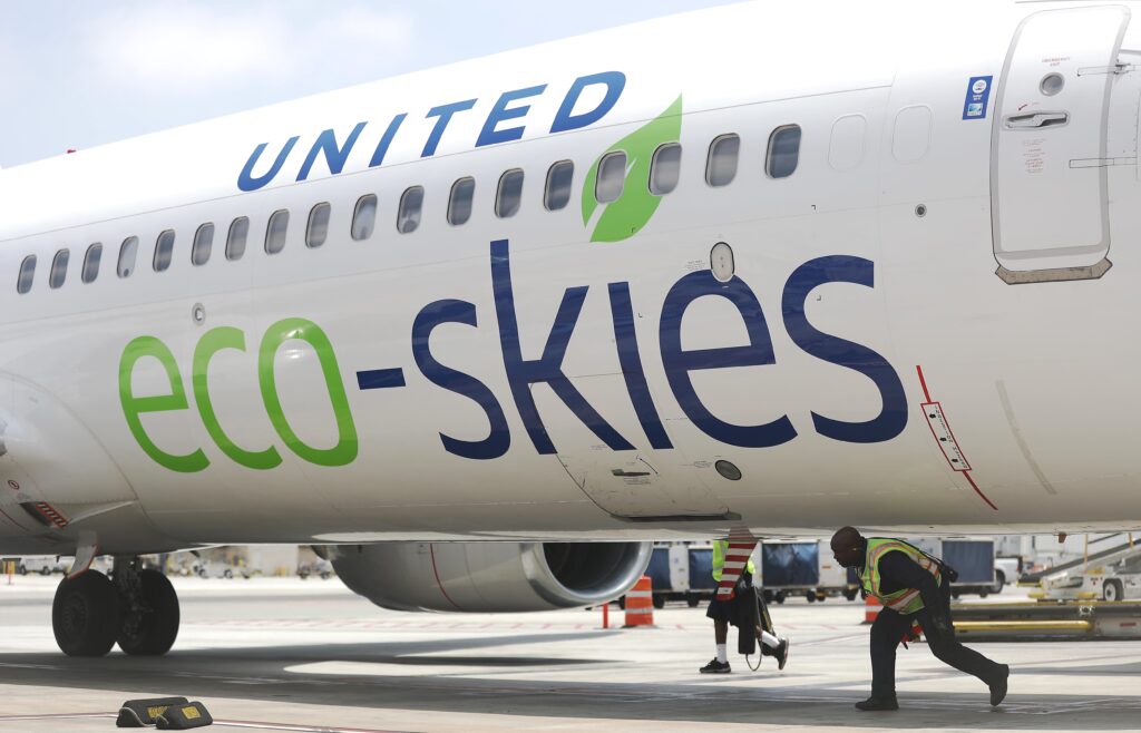 A worker walks beneath a United Airlines Boeing 737-900ER after it arrived at Los Angeles International Airport (LAX) on June 5, 2019. The flight from Chicago to Los Angeles used aviation biofuel, a critical component of airlines’ goal of reaching a net-zero carbon goal by 2050. (Photo by Mario Tama/Getty Images)