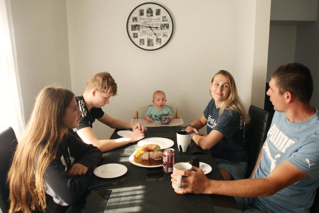 The Biliaze family, including parents Ilona and Valerii, sit at their kitchen table on May 12, 2025, in Watertown. (Makenzie Huber/South Dakota Searchlight)