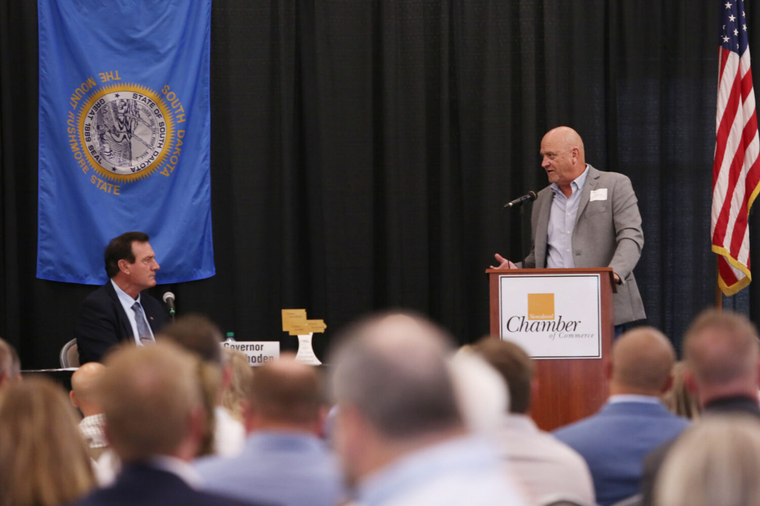 North Sioux City Administrator Jeff Dooley, right, addresses the Tri-State Governors' Conference Aug. 26, 2025, in Dakota Dunes as South Dakota Gov. Larry Rhoden listens. (Makenzie Huber/South Dakota Searchlight)