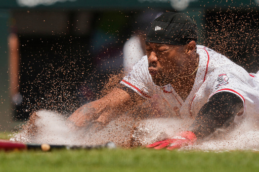 Cincinnati Reds' Will Benson slides safely into home to score on a single hit by Matt McLain during the sixth inning of a baseball game against the Atlanta Braves, Friday, Aug. 1, 2025, in Cincinnati. (AP Photo/Carolyn Kaster)