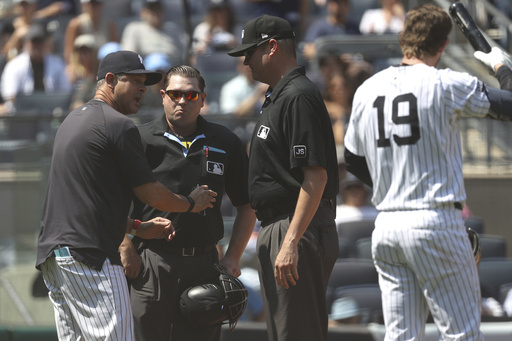 New York Yankees manager Aaron Boone, left, argues with umpires during the third inning of a baseball game against the Houston Astros, Sunday, Aug. 10, 2025, in New York. (AP Photo/Pamela Smith)