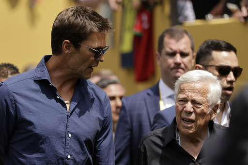 Former New England Patriots quarterback Tom Brady, left, and New England Patriots owner Robert Kraft walk on the field before the Club World Cup final soccer match between Chelsea and PSG in East Rutherford, N.J., Sunday, July 13, 2025. (AP Photo/Adam Hunger)