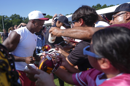 Washington Commanders wide receiver Terry McLaurin signs autographs for fans after a practice at the team's NFL football training camp, Sunday, July 27, 2025, in Ashburn, Va. (AP Photo/Mark Schiefelbein)