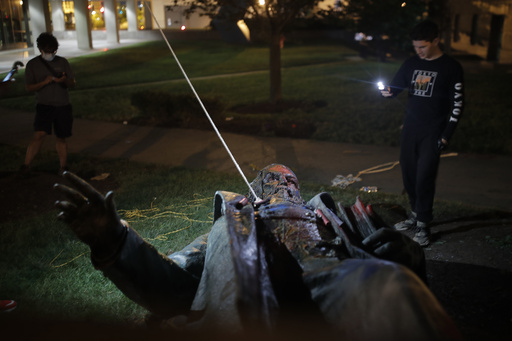 FILE - People film a statue of Confederate general Albert Pike in the nation's capital after it was toppled by protesters and set on fire in Washington early June 20, 2020. (AP Photo/Maya Alleruzzo, File)