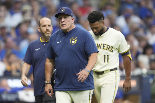 Milwaukee Brewers manager Pat Murphy, middle, walks to the dugout with Jackson Chourio (11) during the fifth inning of a baseball game against the Chicago Cubs, Tuesday, July 29, 2025, in Milwaukee. Chourio was removed from the game after suffering an injury. (AP Photo/Aaron Gash)