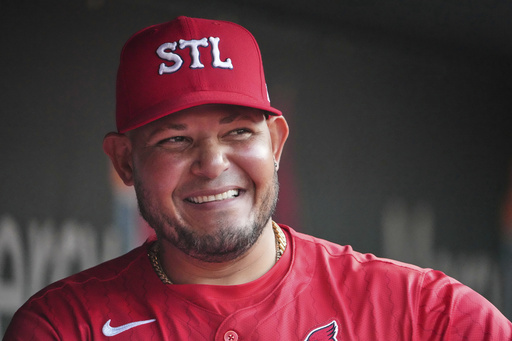 St. Louis Cardinals guest coach Yadier Molina is seen in the dugout before the start of a baseball game against the Chicago Cubs Friday, Aug. 8, 2025, in St. Louis. (AP Photo/Jeff Roberson)