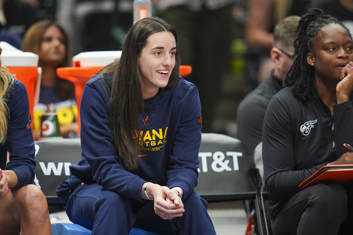 Indiana Fever guard Caitlin Clark looks on from the bench during the first half of a WNBA basketball game against the Dallas Wings Friday, Aug. 1, 2025, in Dallas. (AP Photo/Julio Cortez)