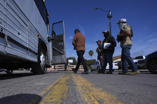 Federal agents escort a man to a transport bus after he was detained following an appearance at immigration court, Tuesday, July 22, 2025, in San Antonio. (AP Photo/Eric Gay)