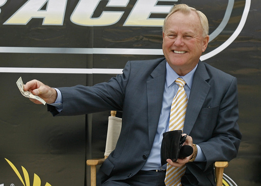 FILE - H.A. "Humpy" Wheeler, president and general manager of Lowe's Motor Speedway, pays up for being late to the news conference to announce the burnout contest that will be held during the pre-race show before the start of the NASCAR Sprint All-Star Race during a new conference at Lowe's Motor Speedway on April 22, in Concord, N.C. (AP Photo/Rick Havner, FILE)