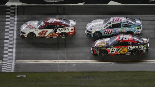 Cole Custer (41) leads Ryan Preece (60), Chase Briscoe (19) and the rest of the field at the halfway point during a NASCAR Cup Series auto race at Daytona International Speedway, Saturday, Aug. 23, 2025, in Daytona Beach, Fla. (AP Photo/John Raoux)