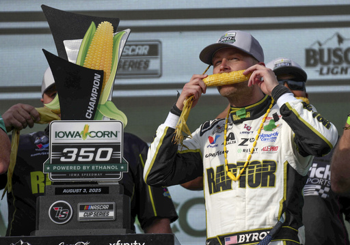 William Byron takes a bite of sweet corn in Victory Lane after winning a NASCAR Cup Series auto race, Sunday, Aug. 3, 2025, at Iowa Speedway in Newton, Iowa. (AP Photo/Bryon Houlgrave)