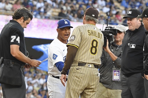 Los Angeles Dodgers manager Dave Roberts, second from left, greets San Diego Padres manager Mike Shildt prior to a baseball game Friday, Aug. 15, 2025, in Los Angeles. (AP Photo/Mark J. Terrill)