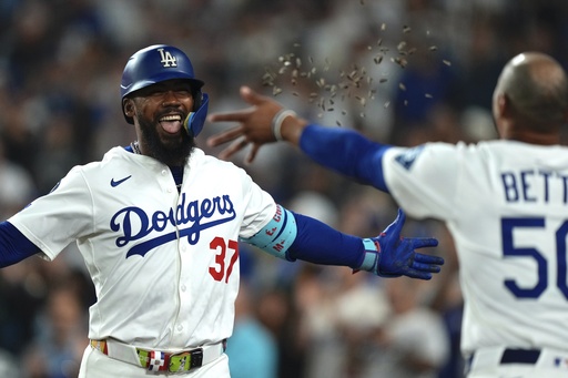 Los Angeles Dodgers' Teoscar Hernández, left, is hit with seeds thrown by Mookie Betts after hitting a solo home run during the seventh inning of a baseball game against the San Diego Padres, Friday, Aug. 15, 2025, in Los Angeles. (AP Photo/Mark J. Terrill)