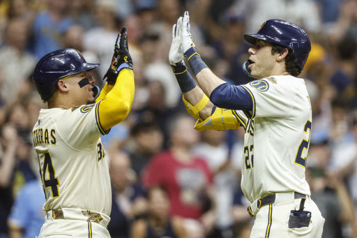 Milwaukee Brewers' Christian Yelich, right, high-fives with William Contreras after Yelich hit a two-run home run against the Pittsburgh Pirates during the fifth inning of a baseball game, Tuesday, Aug.12, 2025, in Milwaukee. (AP Photo/Jeffrey Phelps)