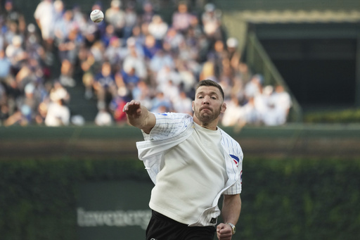 UFC middleweight champion Dricus Du Plessis throws out a ceremonial first pitch before a baseball game between the Cincinnati Reds and the Chicago Cubs in Chicago, Tuesday, Aug. 5, 2025. (AP Photo/Nam Y. Huh)